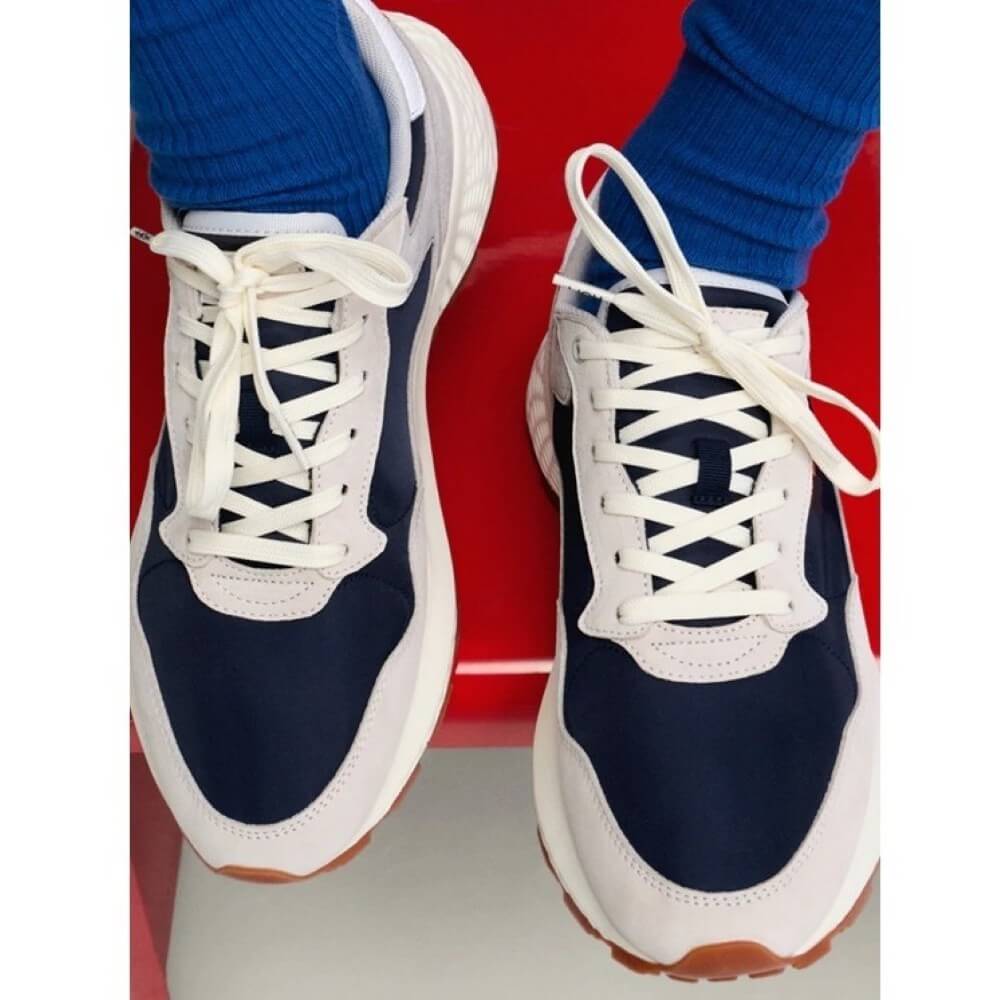 Hoff Navy and white sneakers with blue socks on a red surface