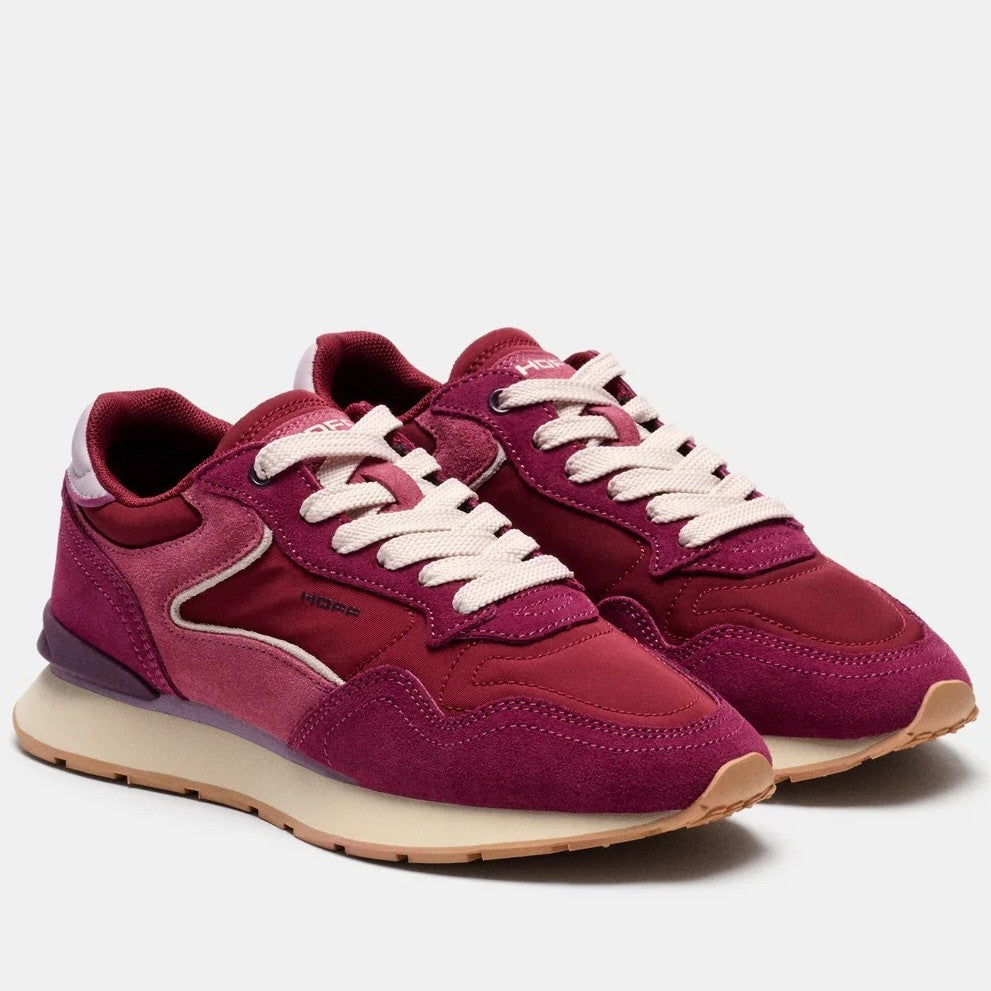 A pair of Hoff low-top sneakers in deep burgundy and magenta suede and textile panels, featuring cream laces and a beige midsole with a gum outsole, shown on a light grey background.