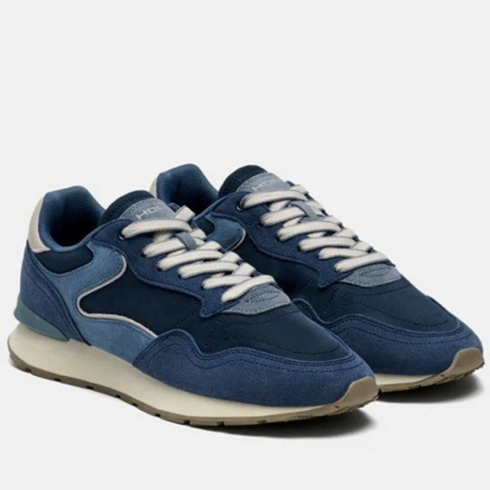 Navy and blue suede sneakers on a light coloured sole 