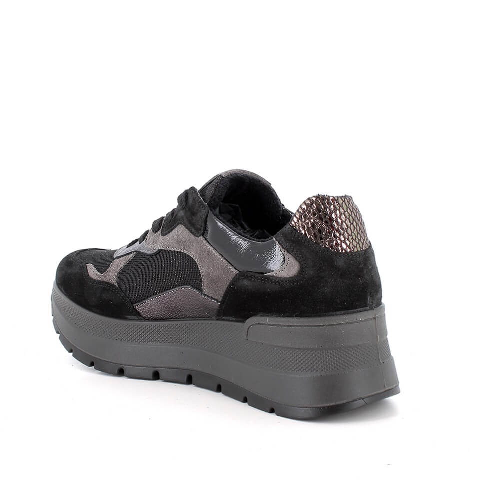 A black and dark gray platform sneaker with a textured snakeskin heel accent, shown from a three-quarters angle on a white background.