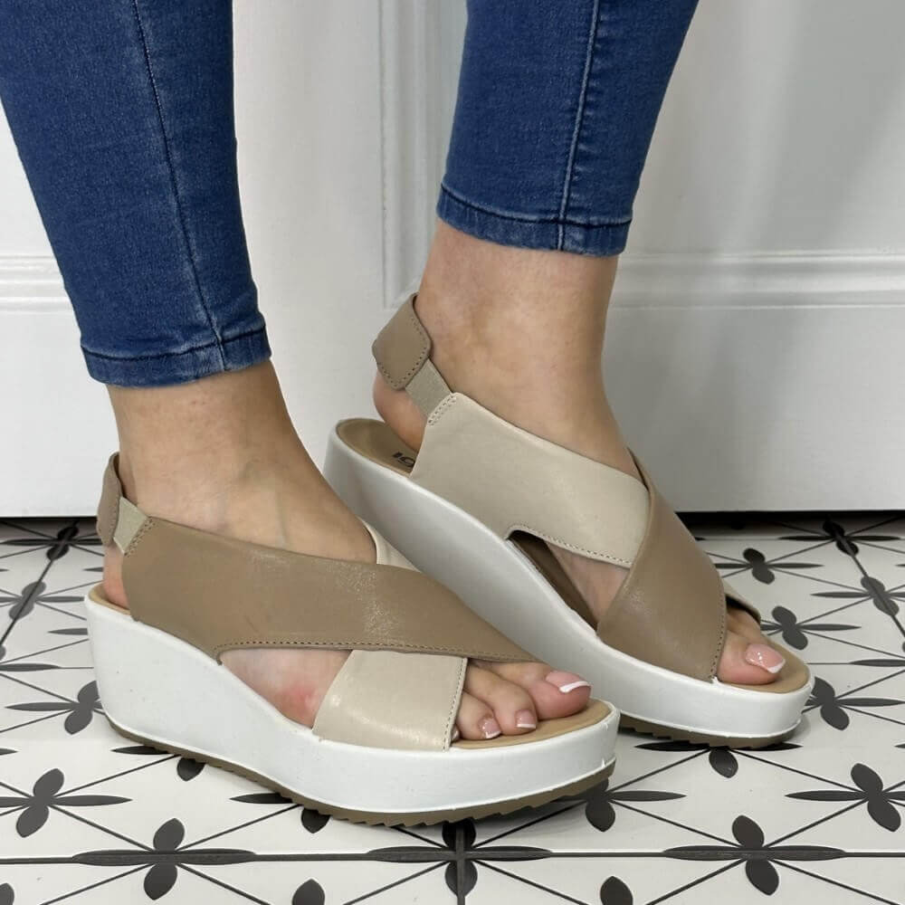 Igi & Co Beige sandals with white soles worn by a person on a patterned floor.