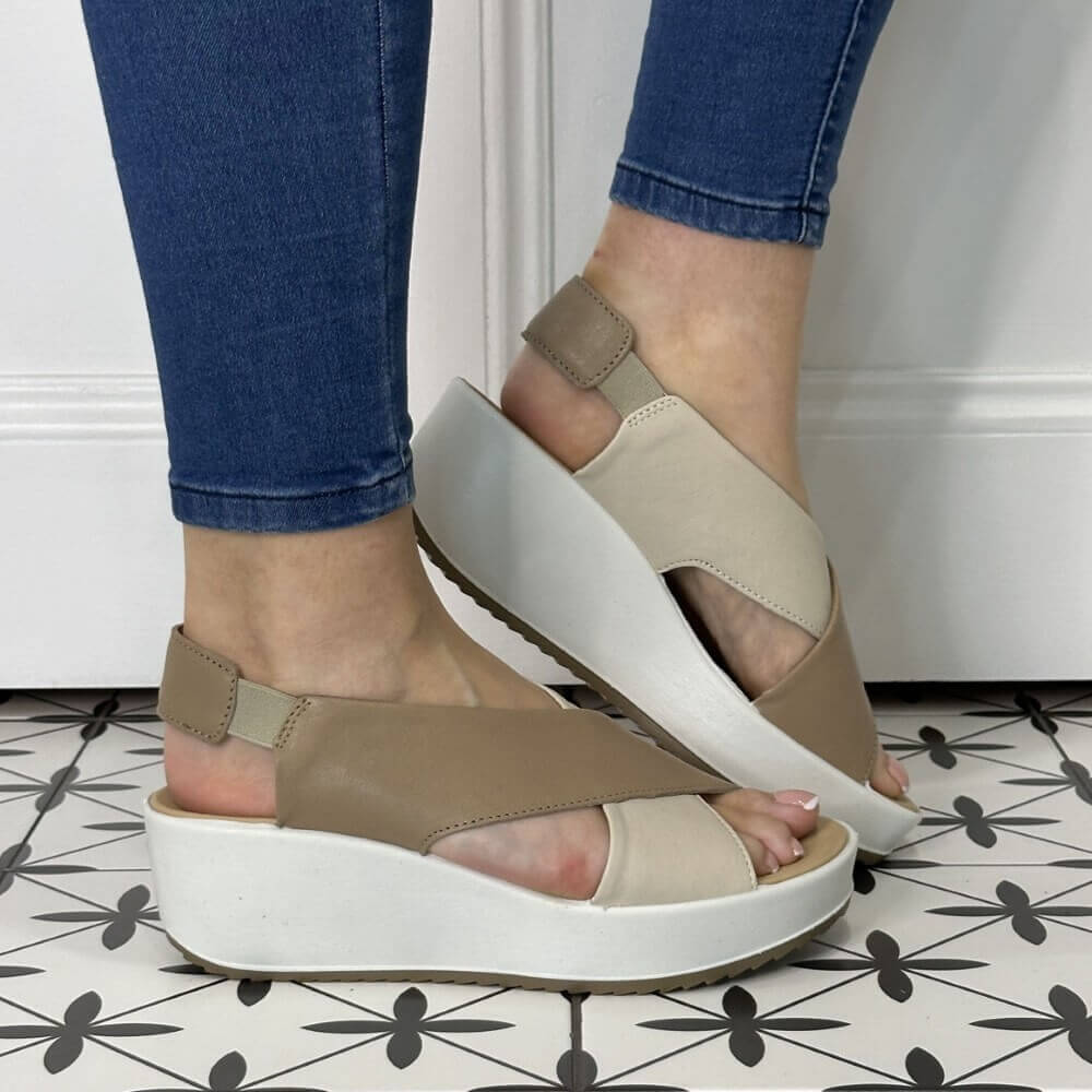 Igi & Co Beige sandals with white soles worn by a person on a patterned floor.