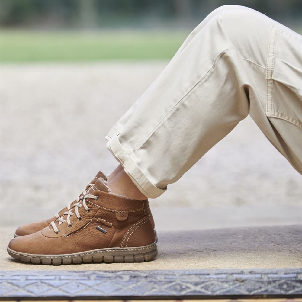 Person wearing Josef Seibel Steffi 53 Waterproof cognac Ankle boots and cream jeans