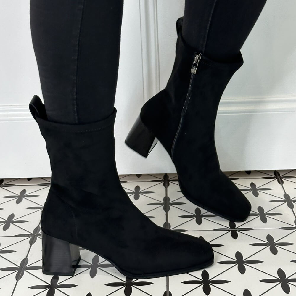 Black ankle boots worn with black pants on a patterned floor. Lodi A-Heka Ankle Boot