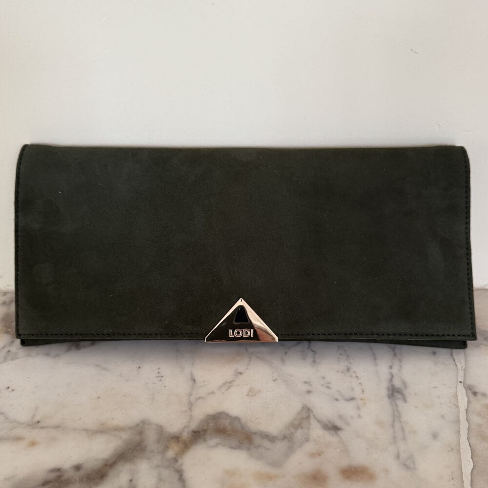 Green suede Lodi clutch bag with gold chain on a marble surface