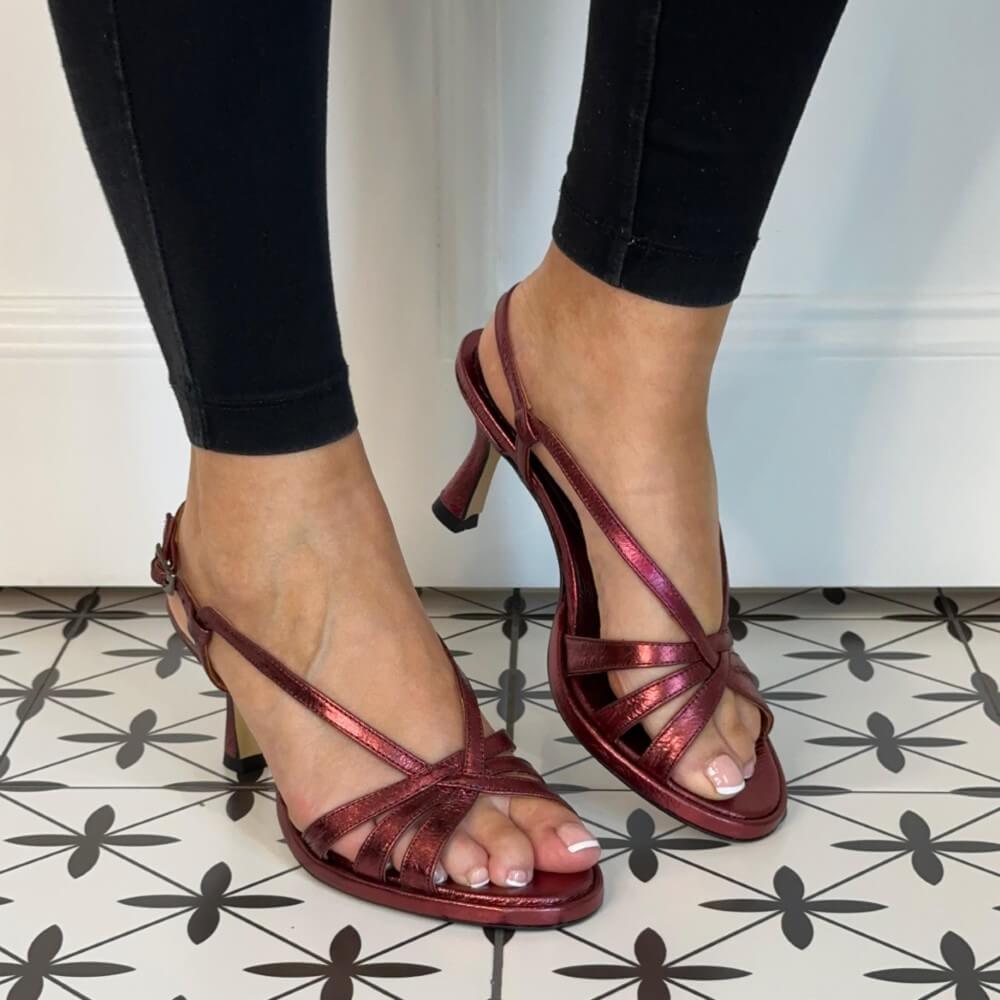 wine Red high-heeled sandals worn with black pants on a patterned floor. MARIAN 53305 Slingback Sandal Burdeos Wine