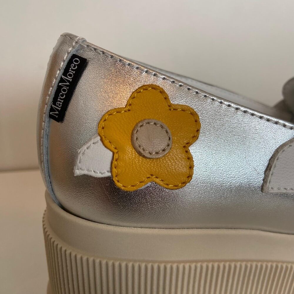 Marco Moreo Silver platform shoe with yellow flower designs on a white background
