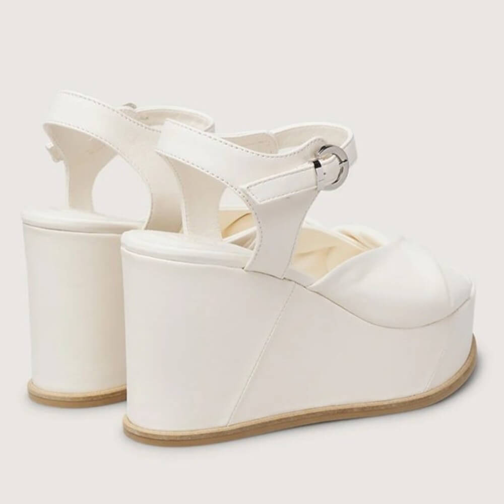 Marco Moreo White wedge sandal with a platform sole on a light gray background