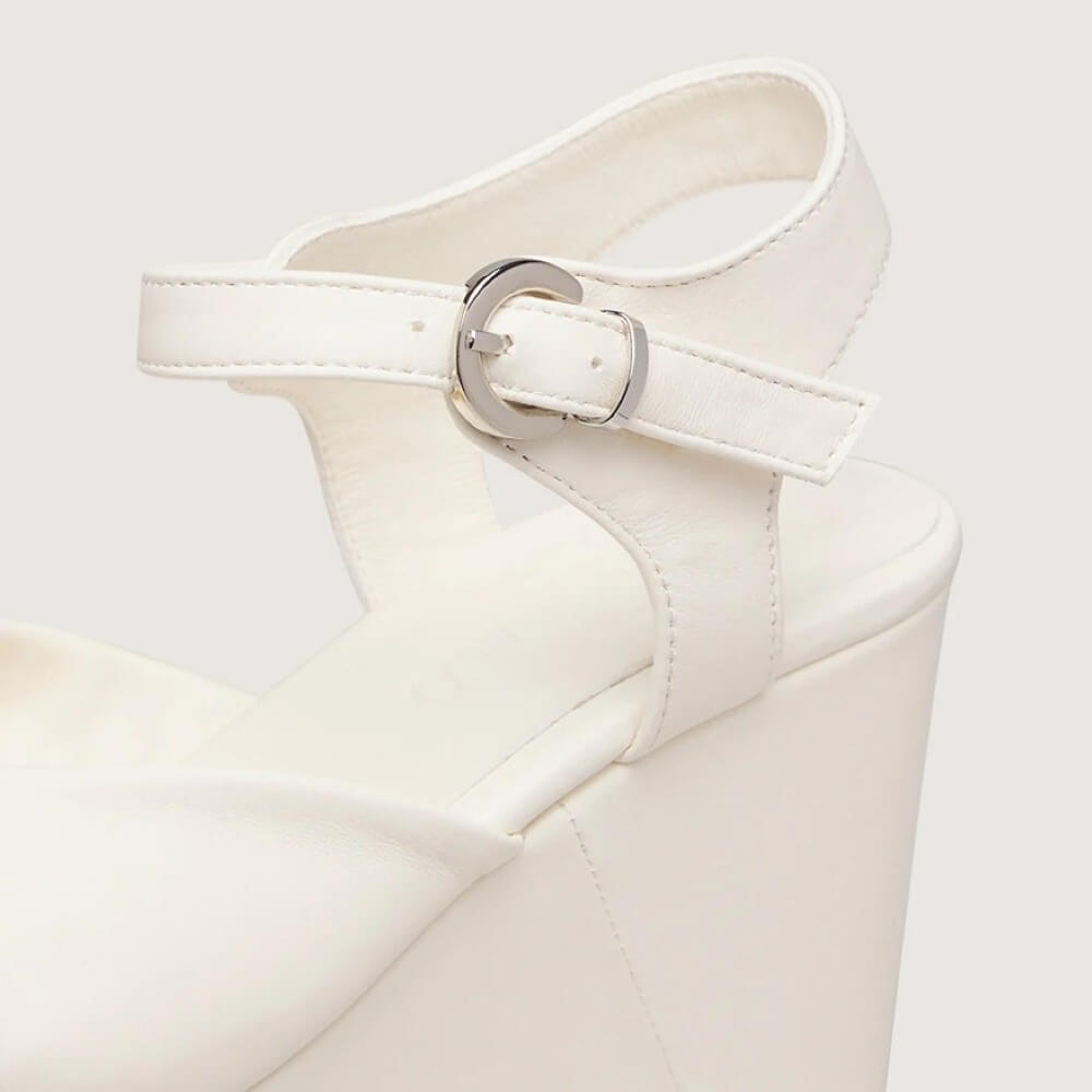 Marco Moreo White wedge sandal with a platform sole on a light gray background
