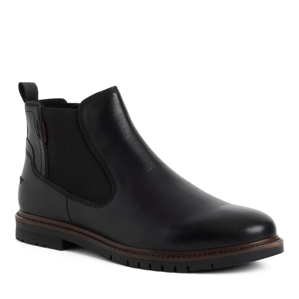 A Marco Tozzi Gents black leather Chelsea ankle boot with a side zipper, elastic side gore, and a brown welt sole, shown in profile against a white background.