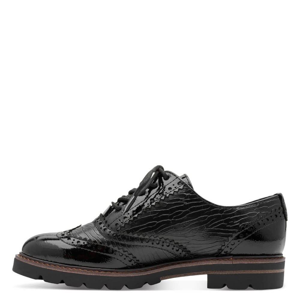 A single black patent vegan leather oxford shoe with a crocodile-embossed texture, brogue detailing, and a chunky lug sole, shown in profile against a white background.