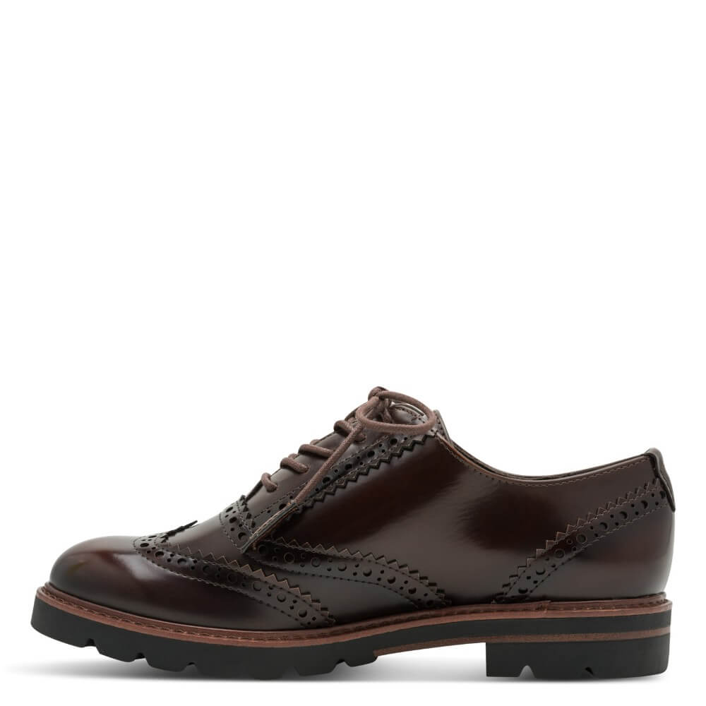 A dark brown vegan leather oxford wingtip shoe with decorative brogue perforations and a chunky black lug sole, shown on a white background.  