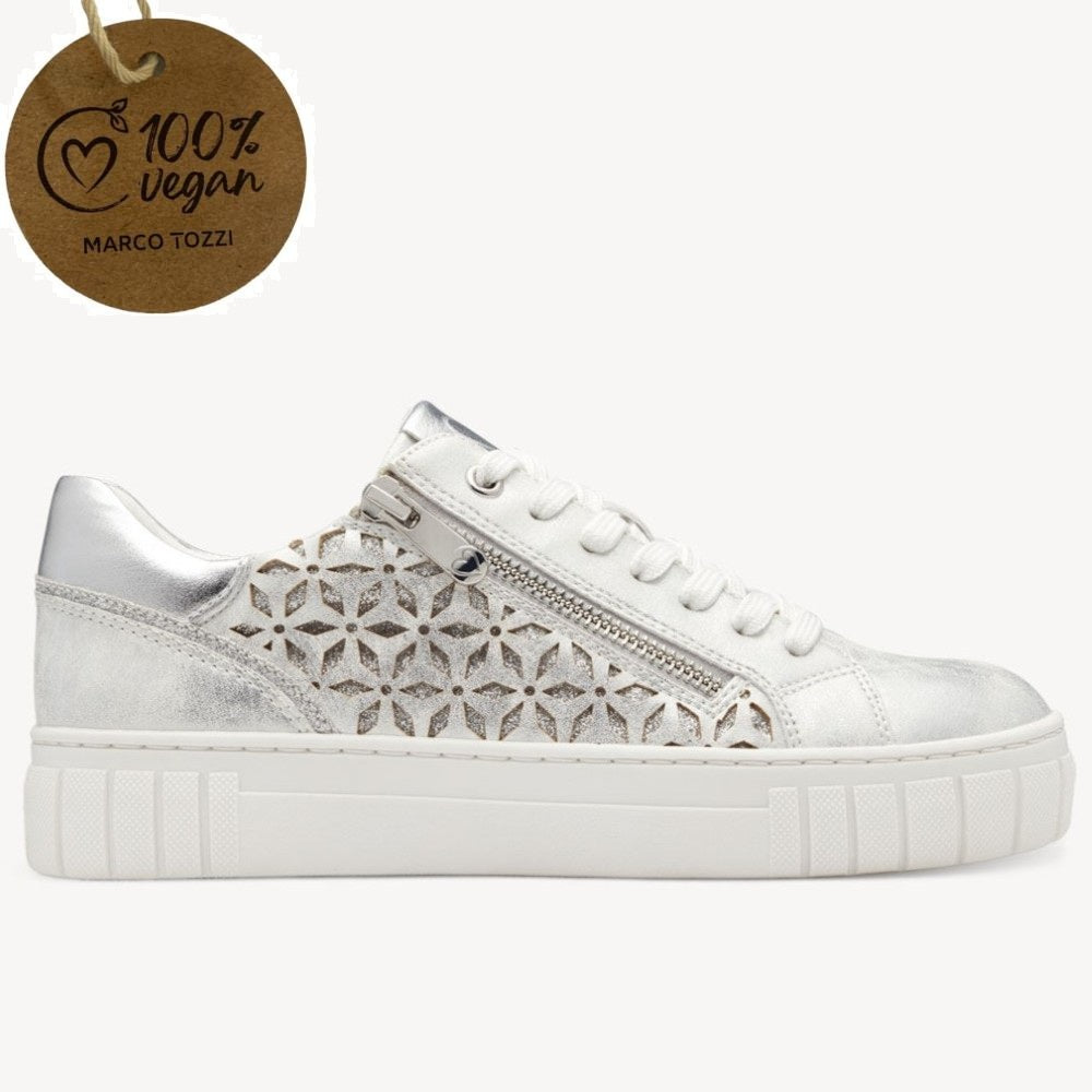 Marco Tozzi sneaker with silver perforated design on a white background, featuring a '100% vegan' label.