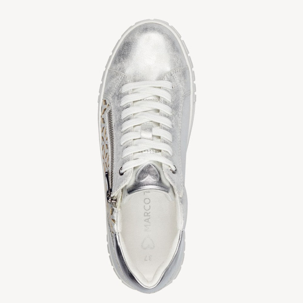 Marco Tozzi Vegan sneaker with silver perforated design on a white background. 