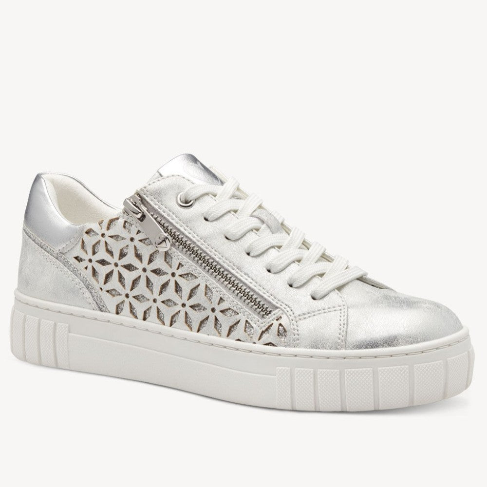 Marco Tozzi Vegan sneaker with silver perforated design on a white background. 
