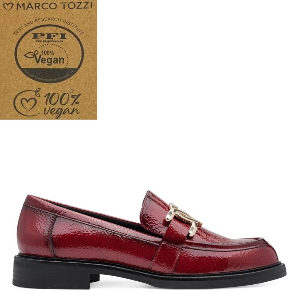 A single red patent loafer by Marco Tozzi, featuring a gold-tone buckle detail and a black sole, shown against a white background with a PFI 100% Vegan certification badge in the top left corner.