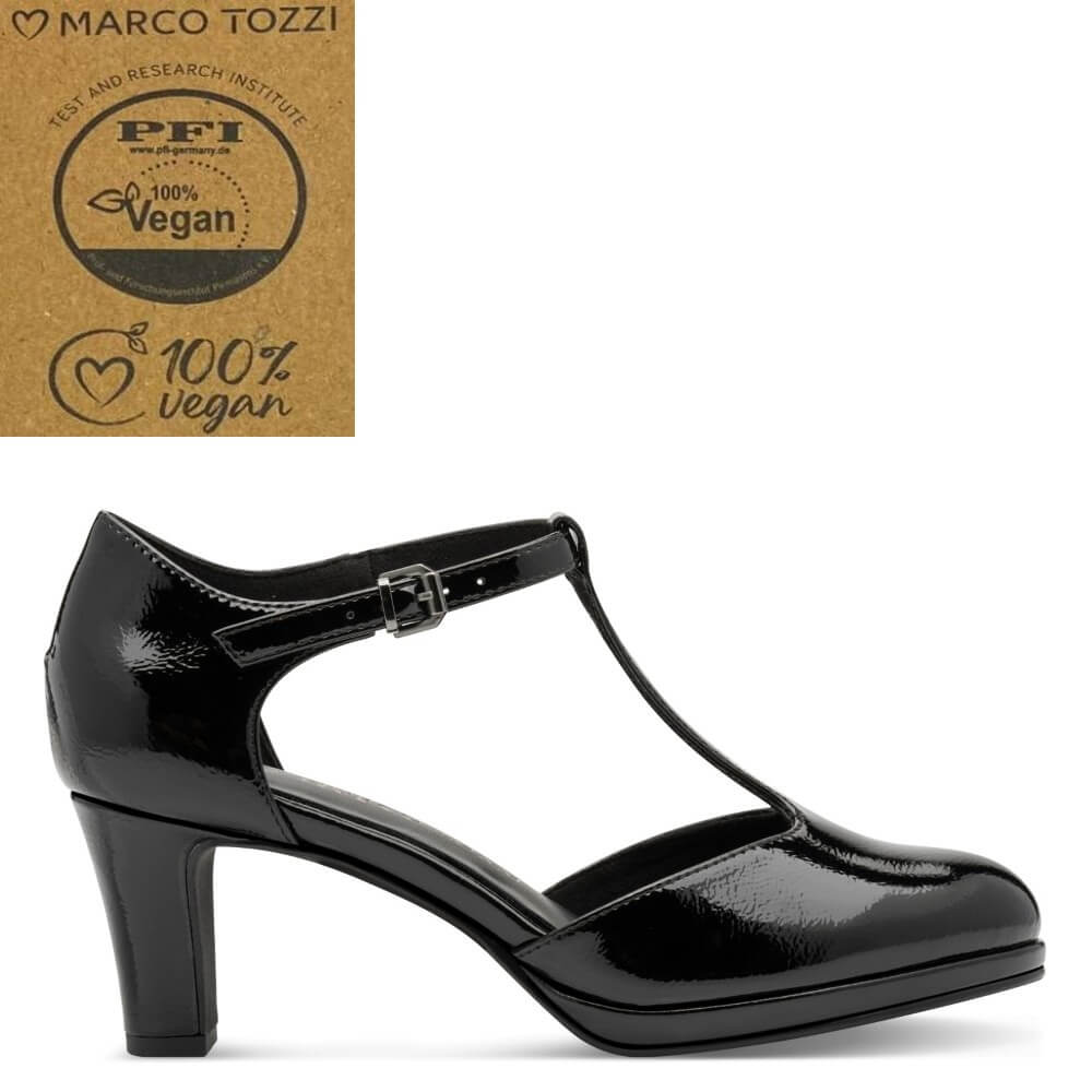 A black patent T-strap high heel shoe by Marco Tozzi, shown in a side profile on a white background. An inset in the top-left corner features  Marco Tozzi brand logo and a 'PFI 100% Vegan' certification seal.