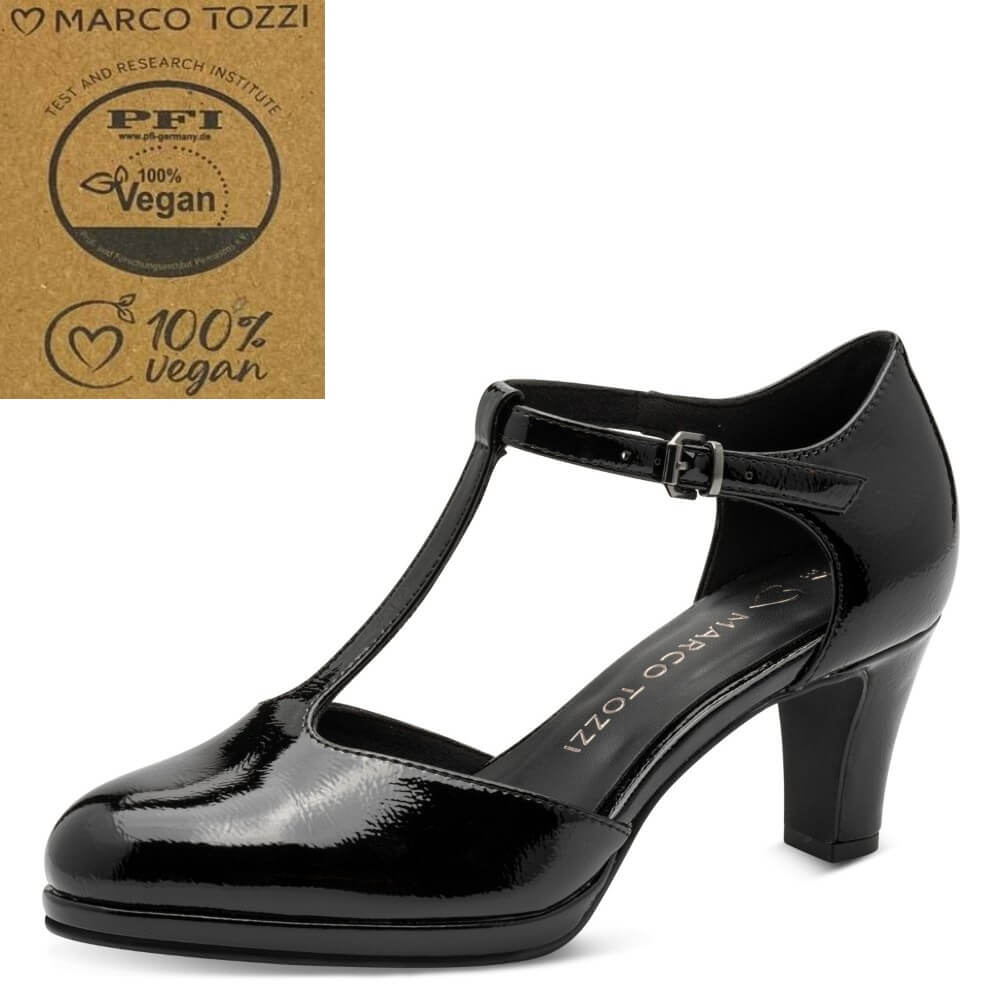 A black patent T-strap high heel shoe by Marco Tozzi, shown in a side profile on a white background. An inset in the top-left corner features  Marco Tozzi brand logo and a 'PFI 100% Vegan' certification seal.