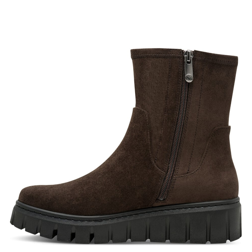 A Marco Tozzi dark brown suede ankle boot with a side zipper and a chunky black lug sole, shown from a side profile view on a white background.
