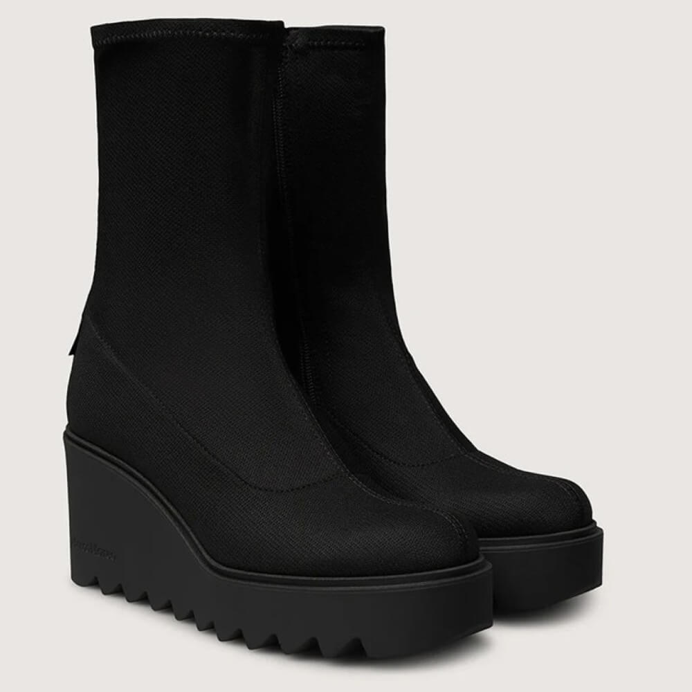 Black wedge ankle boots on a light gray background