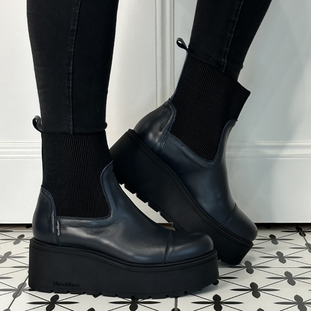 Navy Leather  platform boots worn with black pants on a patterned floor. Marco Moreo A132