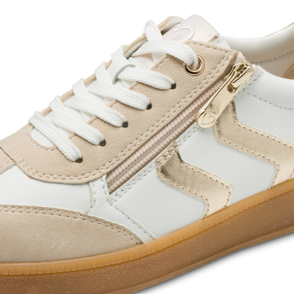 Close-up of a sneaker with beige, Gold and white design on a white background