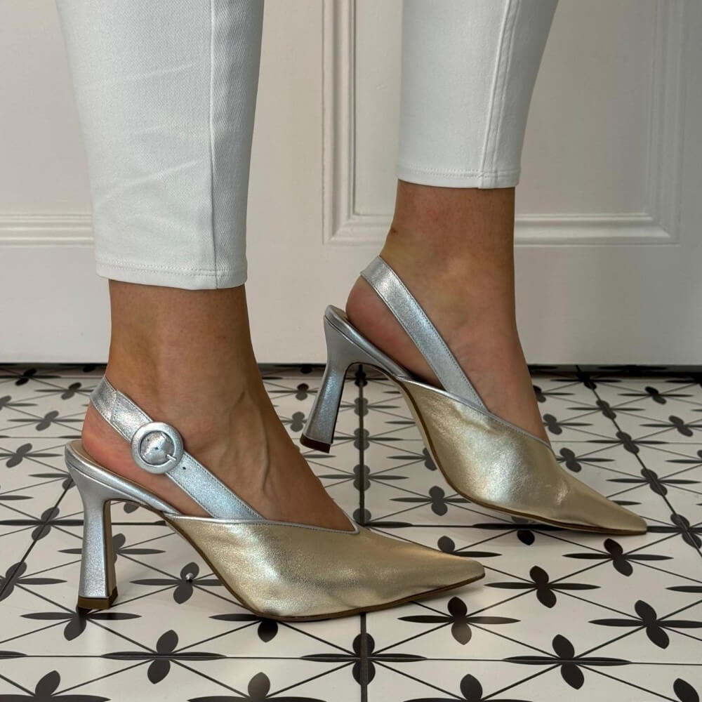 Marian 3406 Gold and Silver high-heeled shoes worn with white pants on a patterned floor.