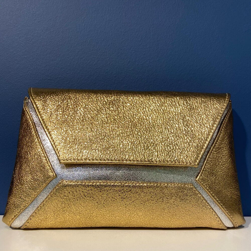 Marian Gold and silver clutch bag on a blue background