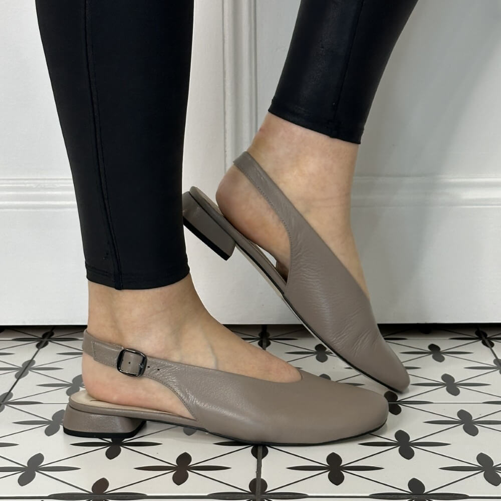 Taupe Leather low slingbacks worn with black leggings on a patterned floor