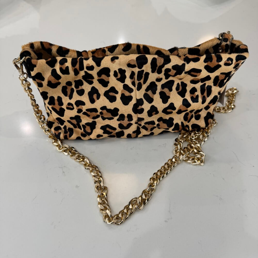 Leopard print handbag with a gold chain on a light gray background