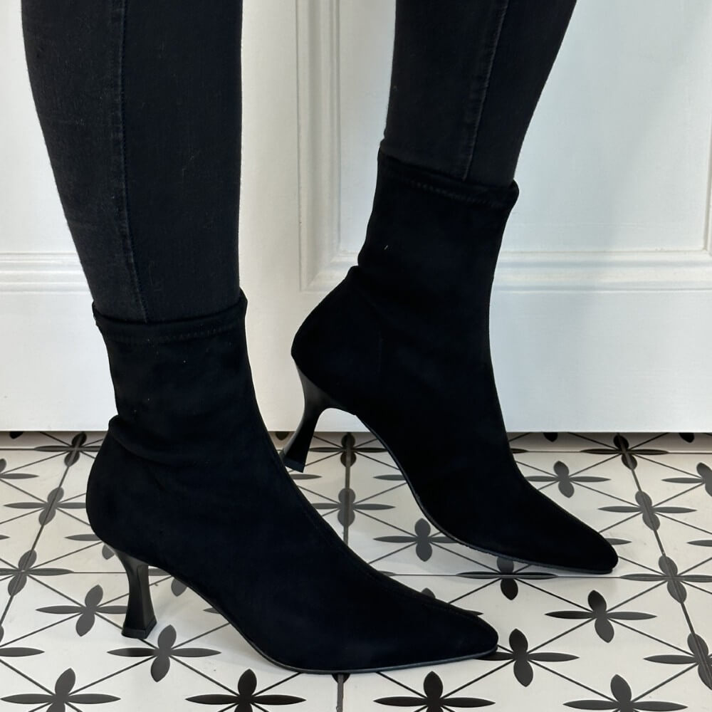 Black sock boots worn with black jeans on a patterned floor. Miss Elastic 78042 Sock Ankle Boot Black