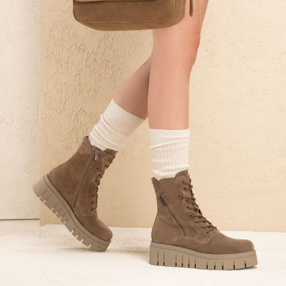 Brown boots worn with white socks against a neutral background Brown suede boot with a platform sole on a white background NeroGiardini Suede combat boots I514911D