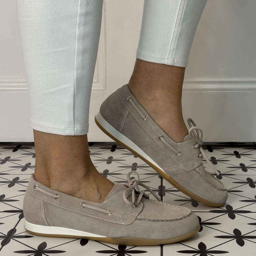 Beige Suede Boat shoes worn with white pants on a patterned floor. E615042D