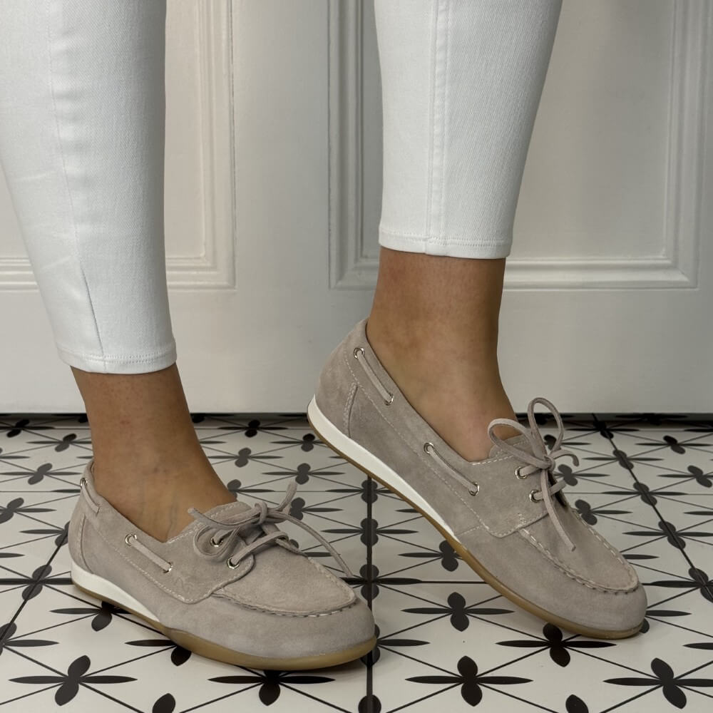 Beige Suede Boat shoes worn with white pants on a patterned floor. E615042D