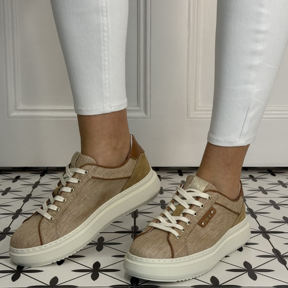 Brown sneakers worn with white pants on a patterned floor. NeroGiardini E615282D