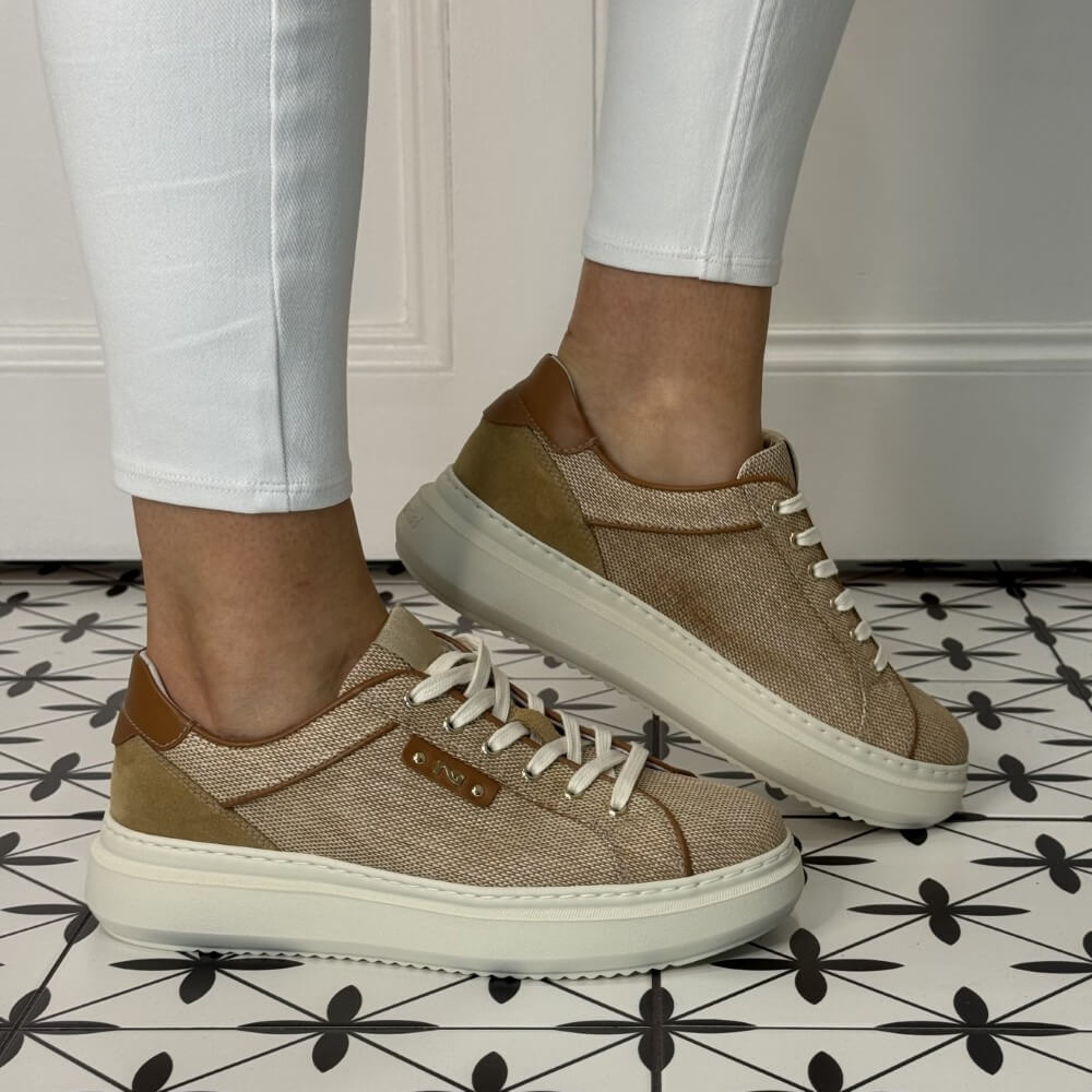 Brown sneakers worn with white pants on a patterned floor. NeroGiardini E615282D