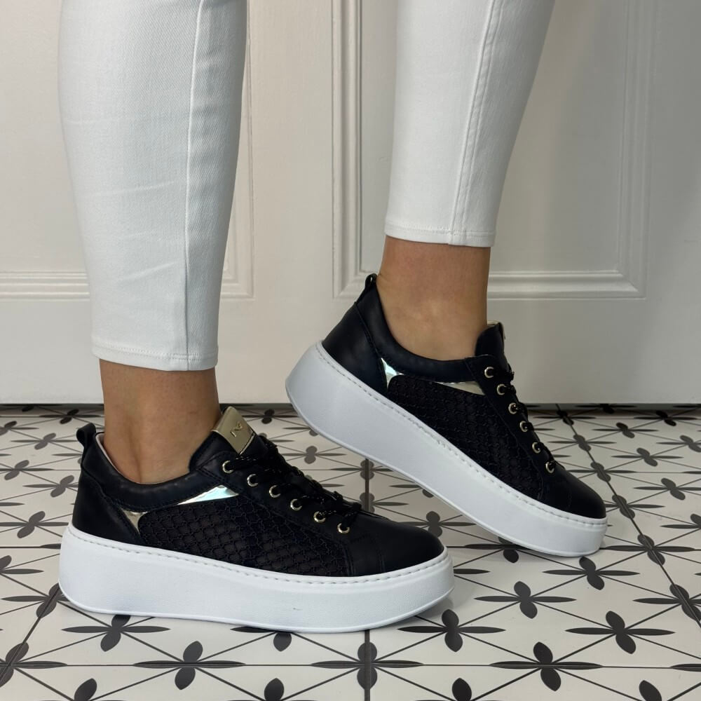 Black Mesh platform sneakers worn with white pants on a patterned floor. NeroGiardini E615292D