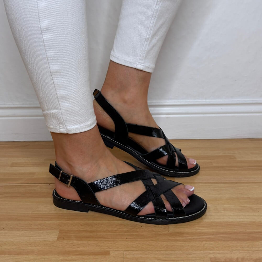 Oh My Sandals 5833 Black sandals worn with white pants on a wooden floor.