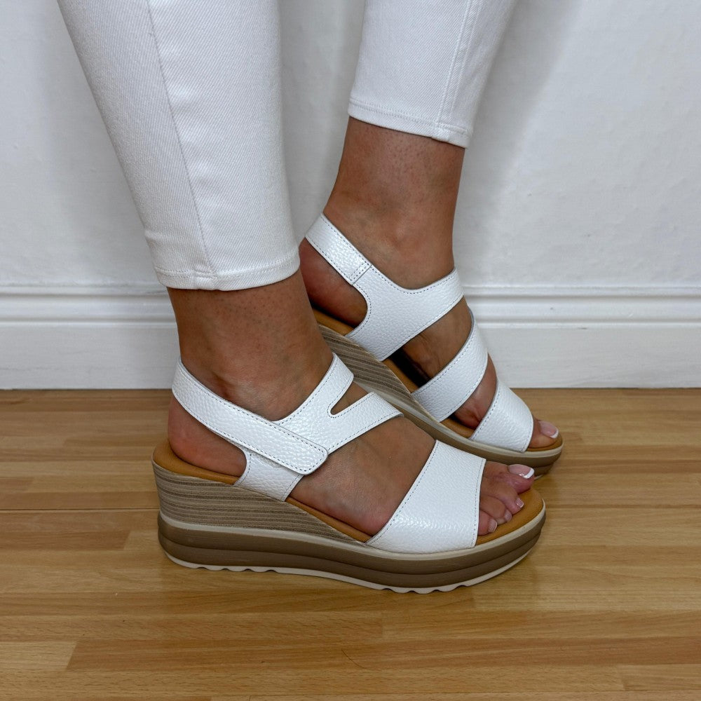 Oh My Sandals 5990 white leather wedge sandals worn with white pants on a wooden floor.