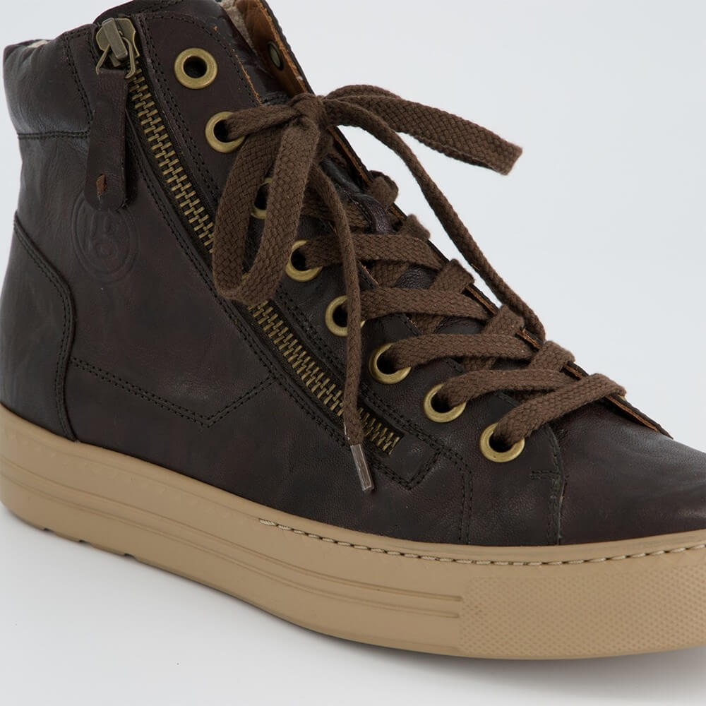 A Paul Green dark brown distressed leather high-top sneaker with a tan rubber sole, brown laces, and a side zipper with brass eyelets, shown from a side profile on a light grey background.