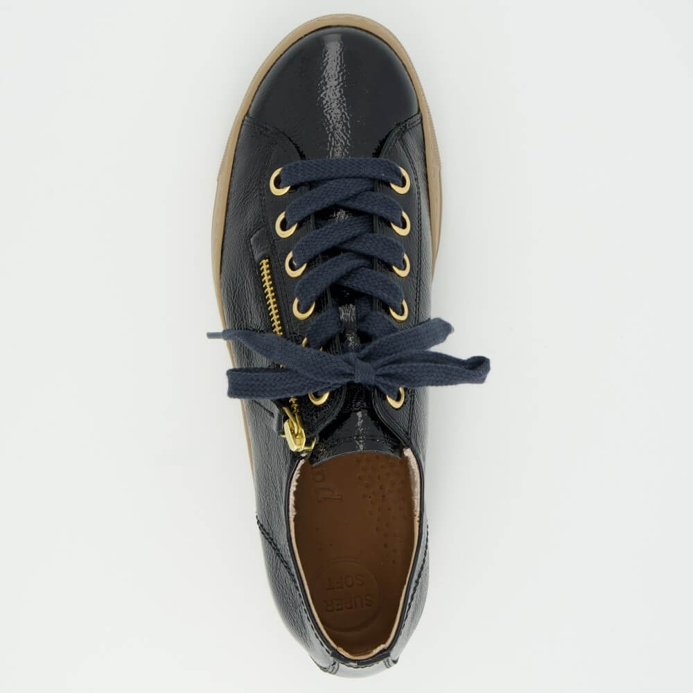 A Paul Green  low-top sneaker in navy blue textured patent leather with a tan sole, navy laces, and gold-tone hardware, shown against a plain light grey background.