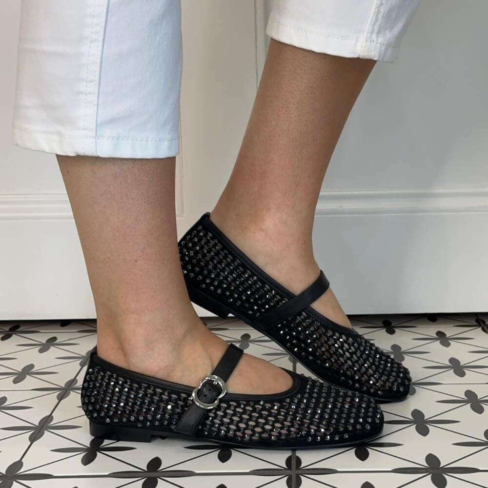 Pedro Anton Black crystal woven shoes with a strap worn by a person on a patterned floor.