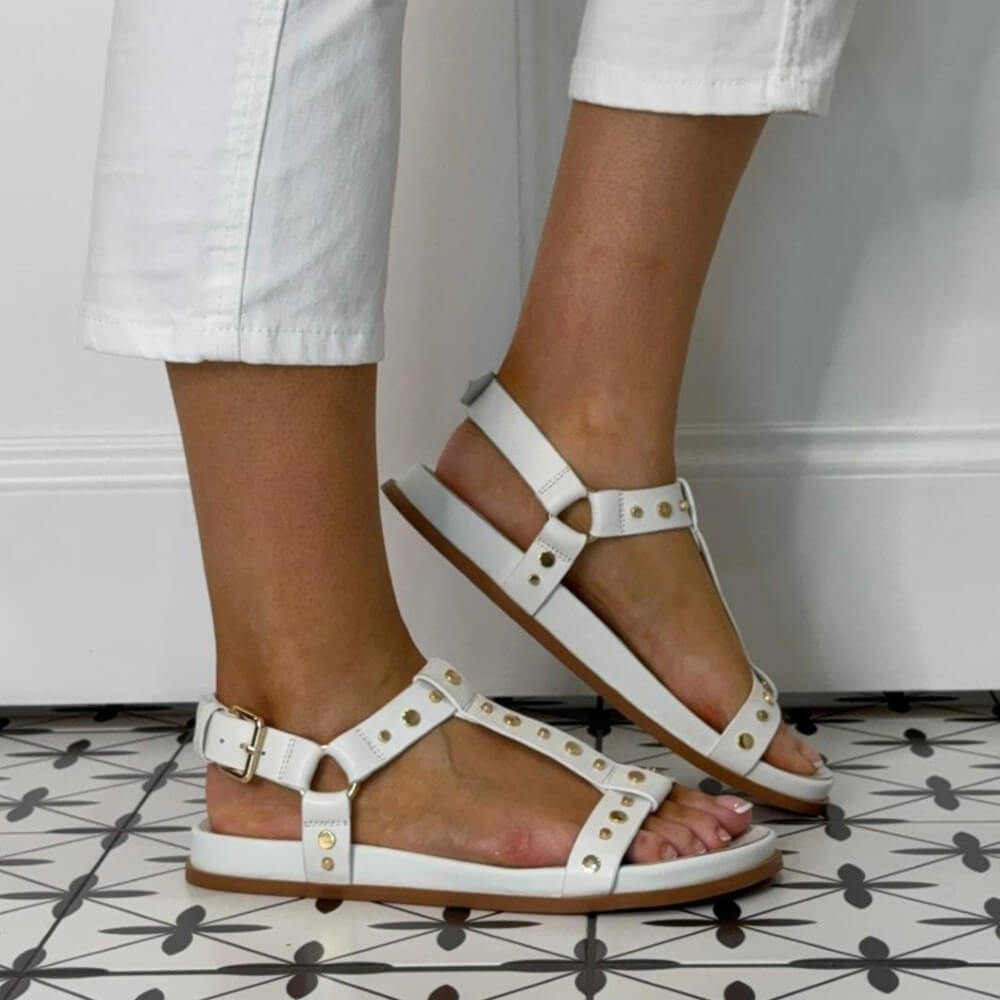 Pedro Anton White sandals with gold accents worn by a person on a patterned floor.