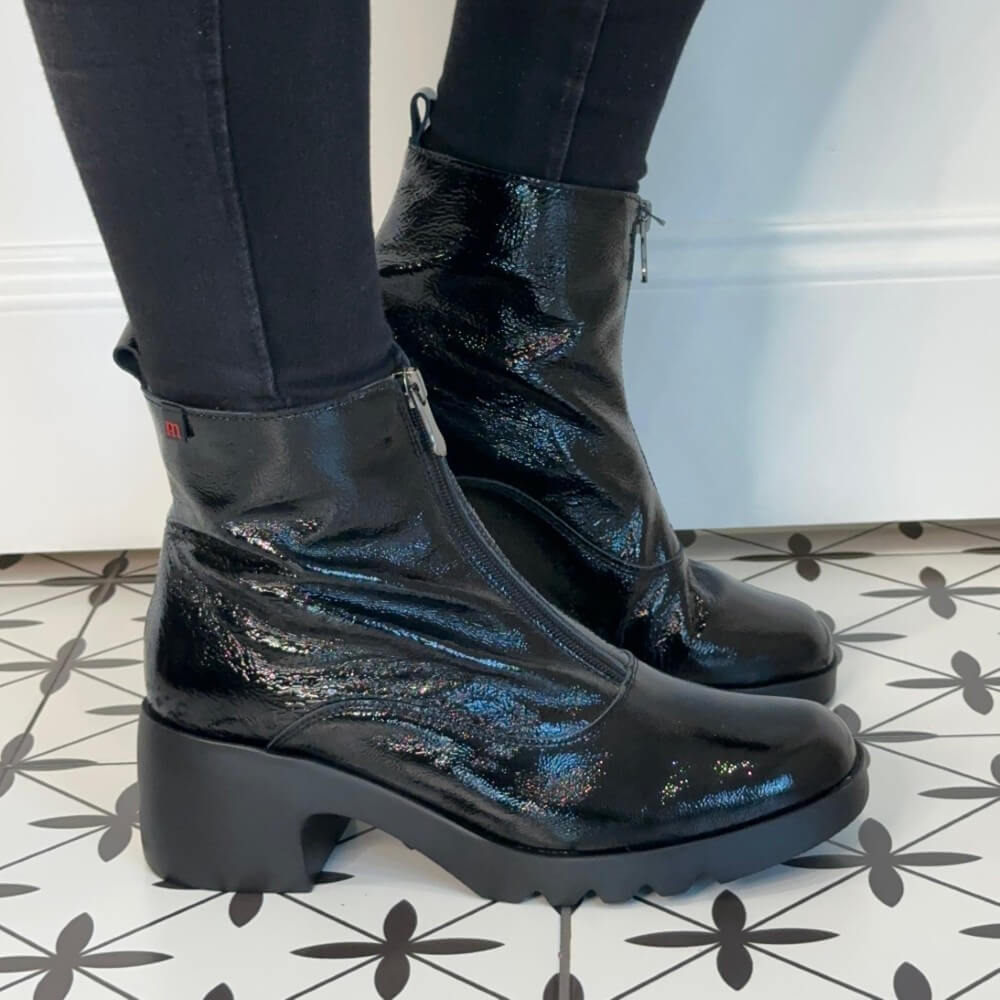 Black patent ankle boots worn with black pants on a tiled floor. Pepe Saenz Ladies Boot 21225 Black