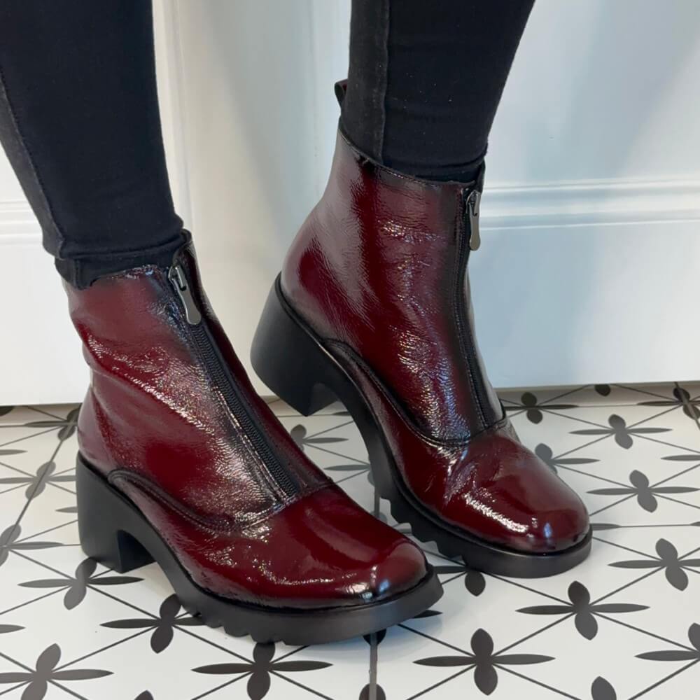 Burgundy Patent leather boots worn with black pants on a patterned floor. Pepe Saenz Patent Leather Ladies Ankle Boot 21225 Wine