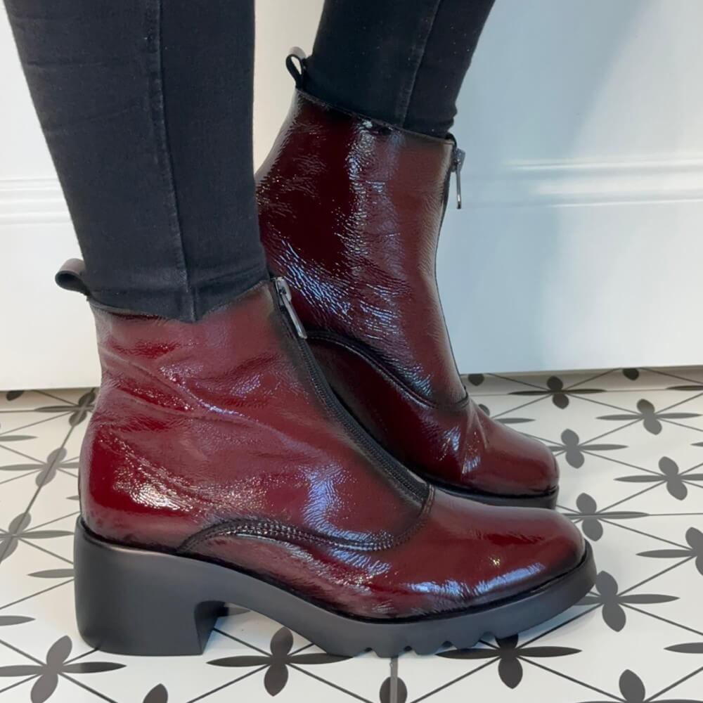 Burgundy Patent leather boots worn with black pants on a patterned floor. Pepe Saenz Patent Leather Ladies Ankle Boot 21225 Wine