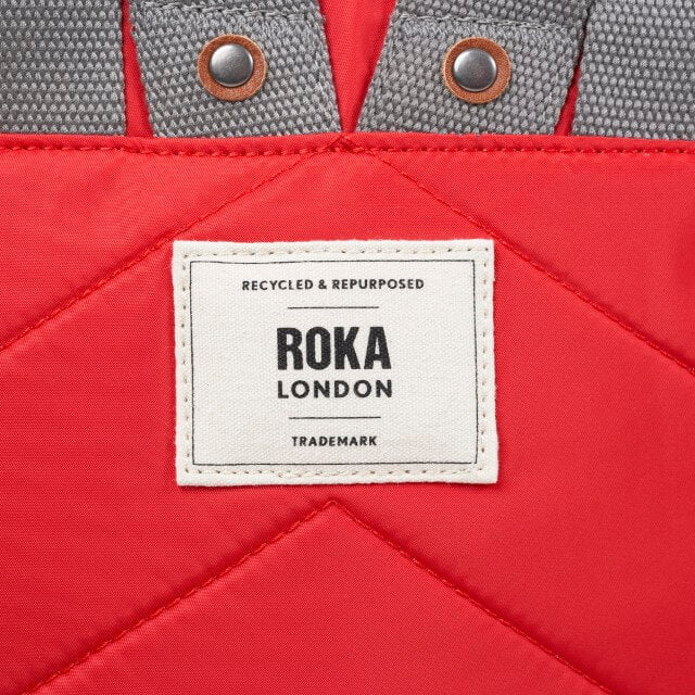 Red bag with a Roka London label on a red background