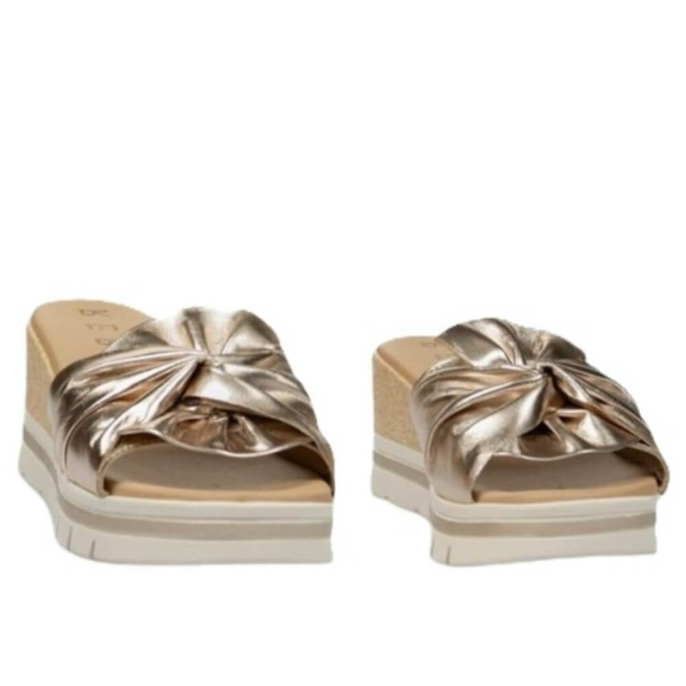 Pair of Repo gold sandals with a knot design on a white background