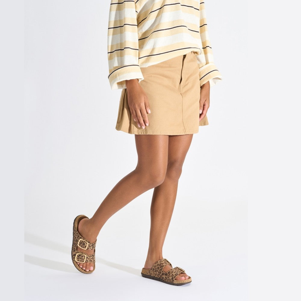 Person wearing a striped shirt, beige skirt, and Rohde leopard print sandals on a white background