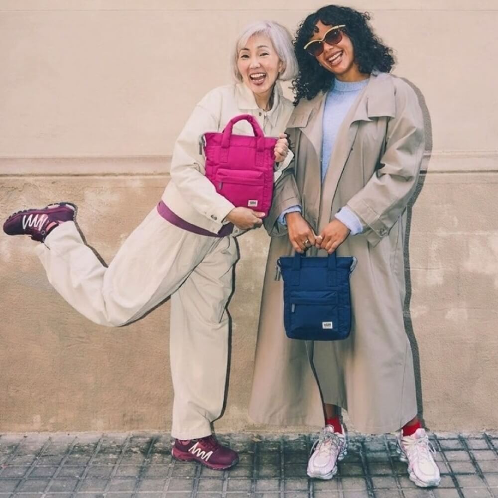 Two women holding Roka Backpacks 